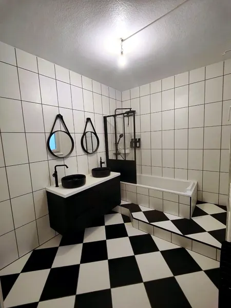 Salle de bain en damier noir et blanc avec double vasque, posée par Yoann Micallef